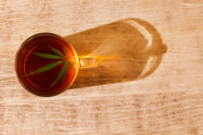 Cup of tea with a hemp leaf