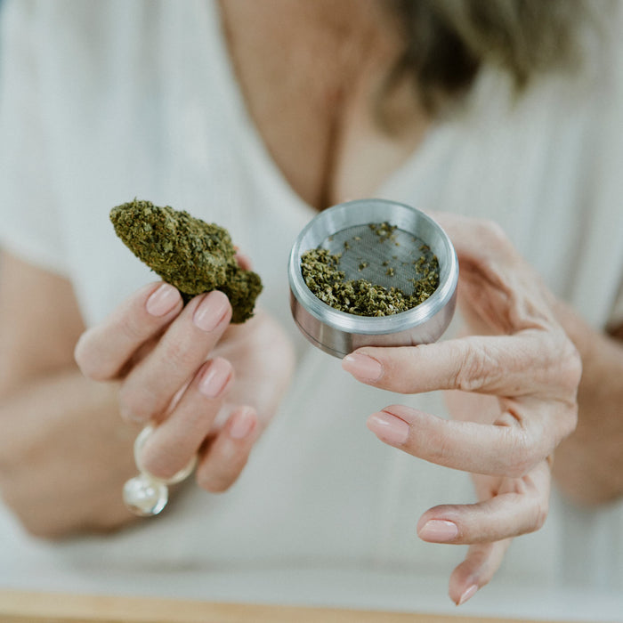 Person holding a cannabis bud and grinder